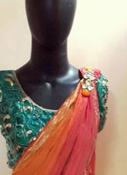 The lovely pinkish orange brooch saree